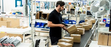 Un préparateur de commandes scanne une série de marchandises.