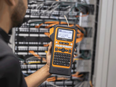 <p>Network installer holding PT-E310 labelling machine in data centre </p>