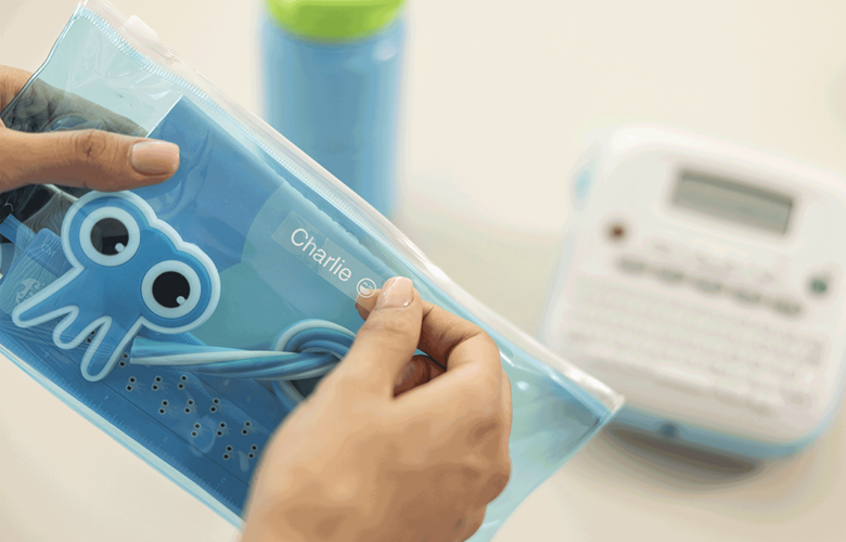 Mother labelling kid's pencil case with Btag label 